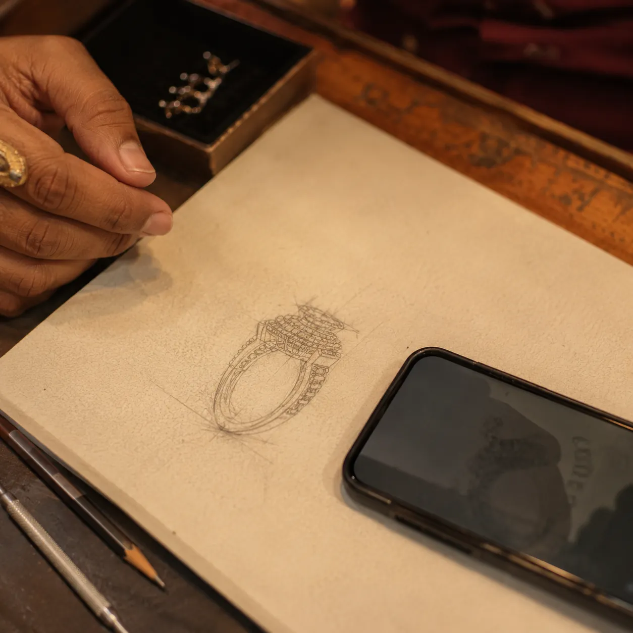 A pencil sketch of a ring being photographed