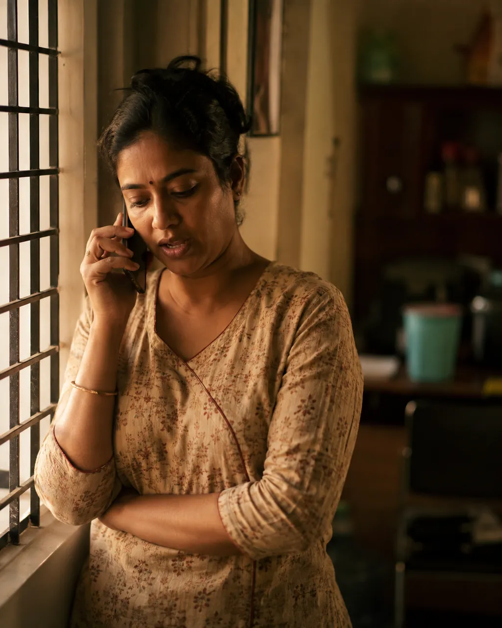 A learner on the phone with her Saathik at a window